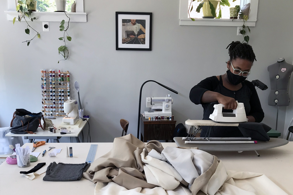 hand pulling fabric through sewing machine